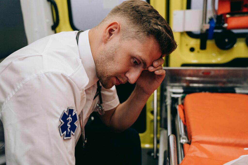 A Tired Paramedic Holding His Head